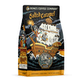 The front of a 12 ounce bag of Bones Coffee Company Salted Caramel coffee. Its flavor is salted caramel, and it has a skeleton dressed up as pirate on the bow of the ship with a treasure chest of salted caramel behind it on the art.